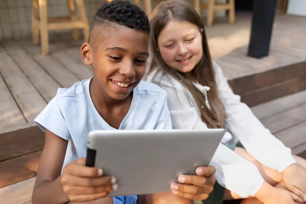 Two children enjoying a tablet connected with Opus Broadband